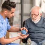 allied health professional working with a patient undergoing occupational therapy