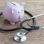 Piggy bank and stethoscope representing increasing physician wealth